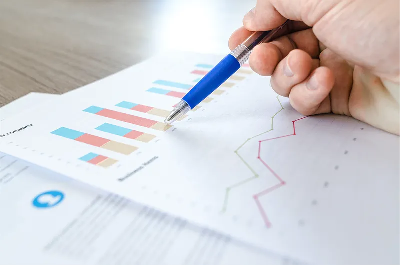 Datastrategie opzetten in 10 stappen Hand wijst naar grafieken en datavisualisaties op een rapport